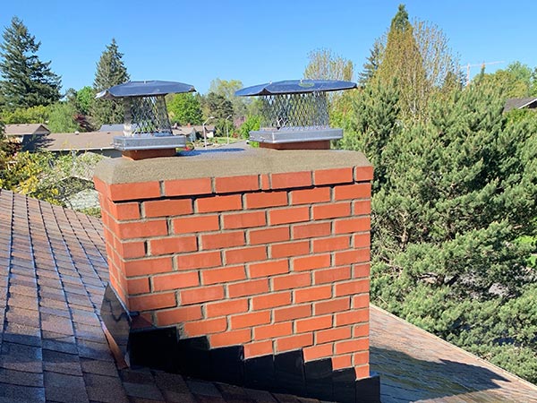 A rebuilt brick chimney with new chimney caps after repair A rebuilt brick chimney with new chimney caps after repair